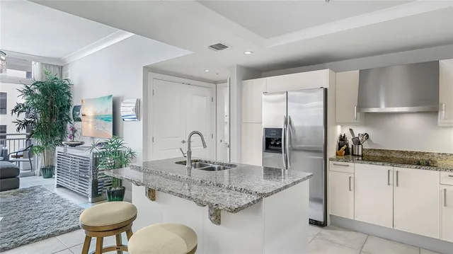 a kitchen with stainless steel appliances granite countertop a kitchen island a stove a sink a dining table and chairs