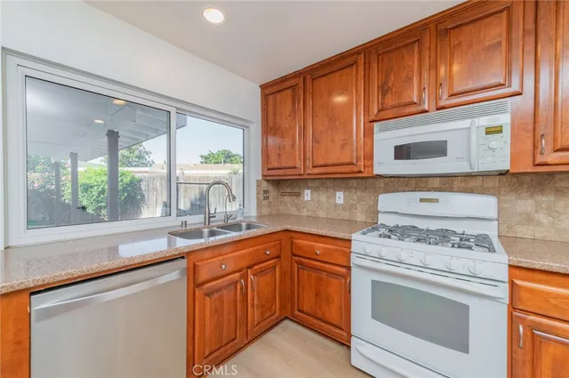 a kitchen with stainless steel appliances granite countertop a sink stove and cabinets