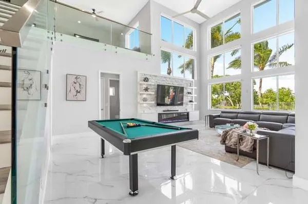 a room with furniture pool table and windows