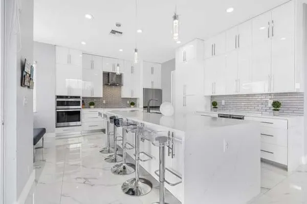 a kitchen with white cabinets and stainless steel appliances