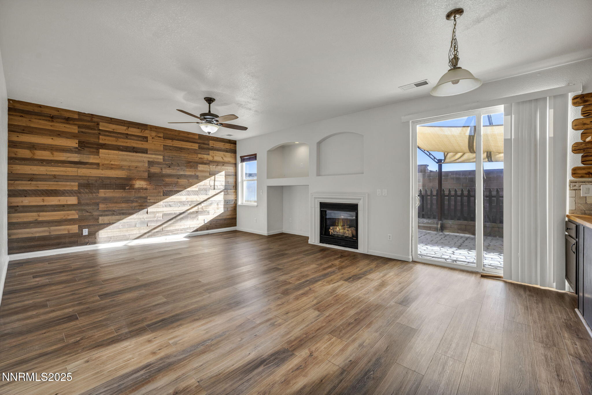 119 Red Oak Court Fernley, NV 89408 - Photo 10 of 64 a view of empty room with wooden floor and fireplace