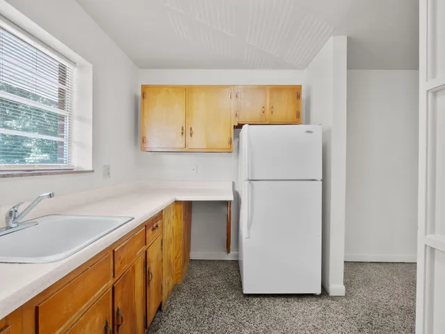 a view of a kitchen with a sink and refrigerator
