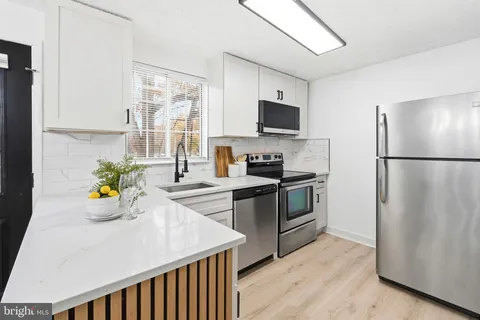 a kitchen with stainless steel appliances a sink a stove and a refrigerator