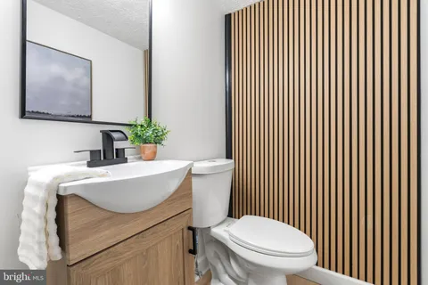 a bathroom with a sink a toilet and mirror