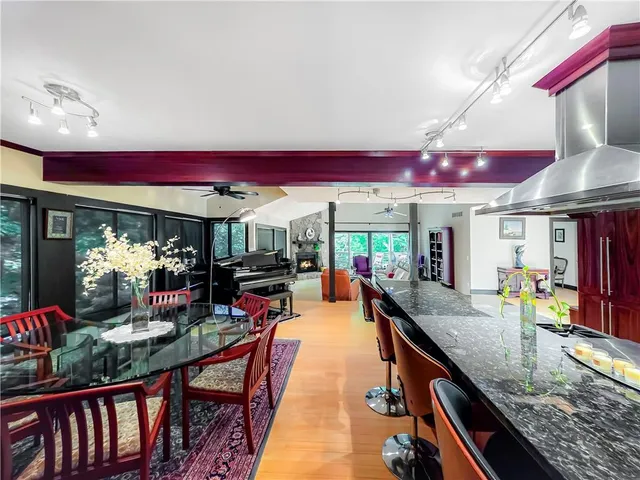 a kitchen with stainless steel appliances granite countertop a kitchen island a stove and a living room view