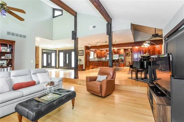 a living room with furniture and a dining table with wooden floor