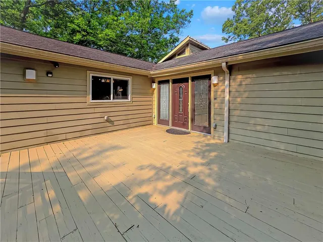 a view of house with backyard and trees in the background