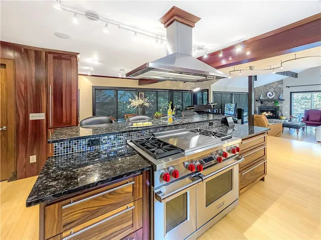 a kitchen with stainless steel appliances granite countertop a stove and a dining table