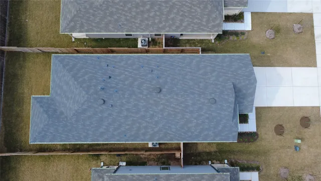 an aerial view of residential houses with outdoor space and parking