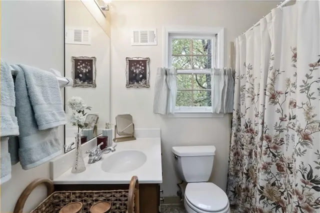 a bathroom with a toilet sink and mirror