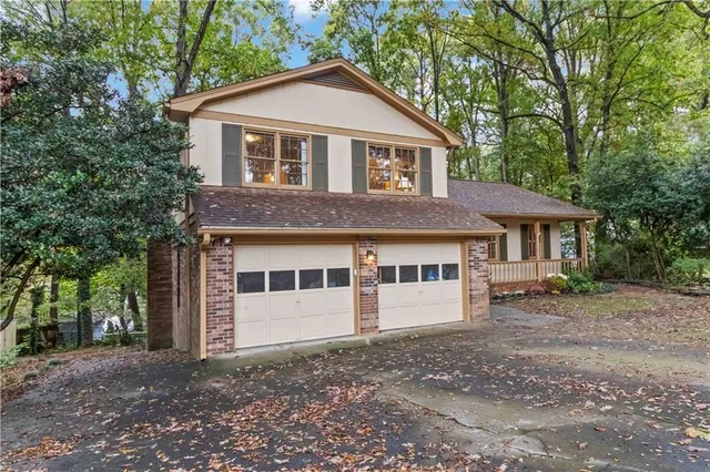 a view of a house with a yard and large trees