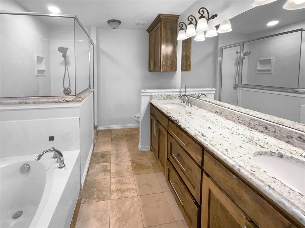 3915 Tower Circle Nevada, TX 75173 - Photo 23 of 29 a spacious bathroom with a granite countertop sink a mirror a shower and bathtub