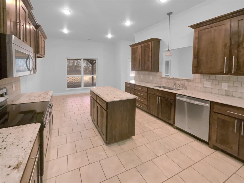 3915 Tower Circle Nevada, TX 75173 - Photo 4 of 29 a large kitchen with stainless steel appliances a stove sink and cabinets