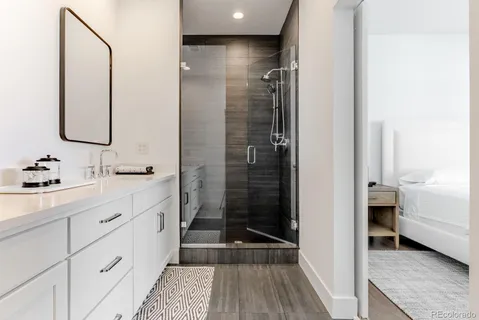 a bathroom with a double vanity sink a mirror and a shower