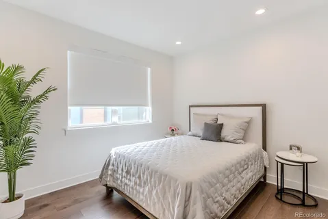 a bedroom with a large bed and a potted plant
