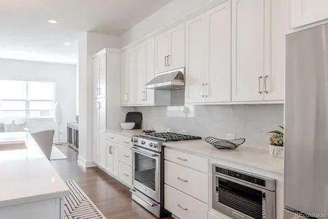 a kitchen with stainless steel appliances white cabinets and a stove a oven with white countertops