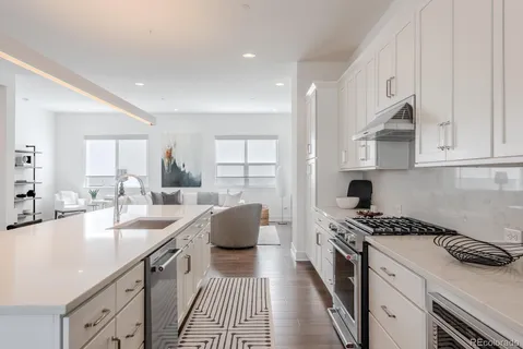 a kitchen with granite countertop a sink stove and cabinets