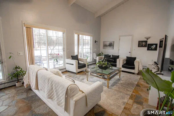 a living room with furniture large window and a flat screen tv