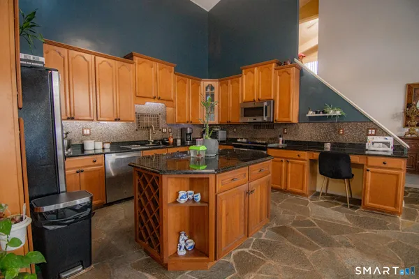 a kitchen with stainless steel appliances granite countertop a stove a sink and a microwave