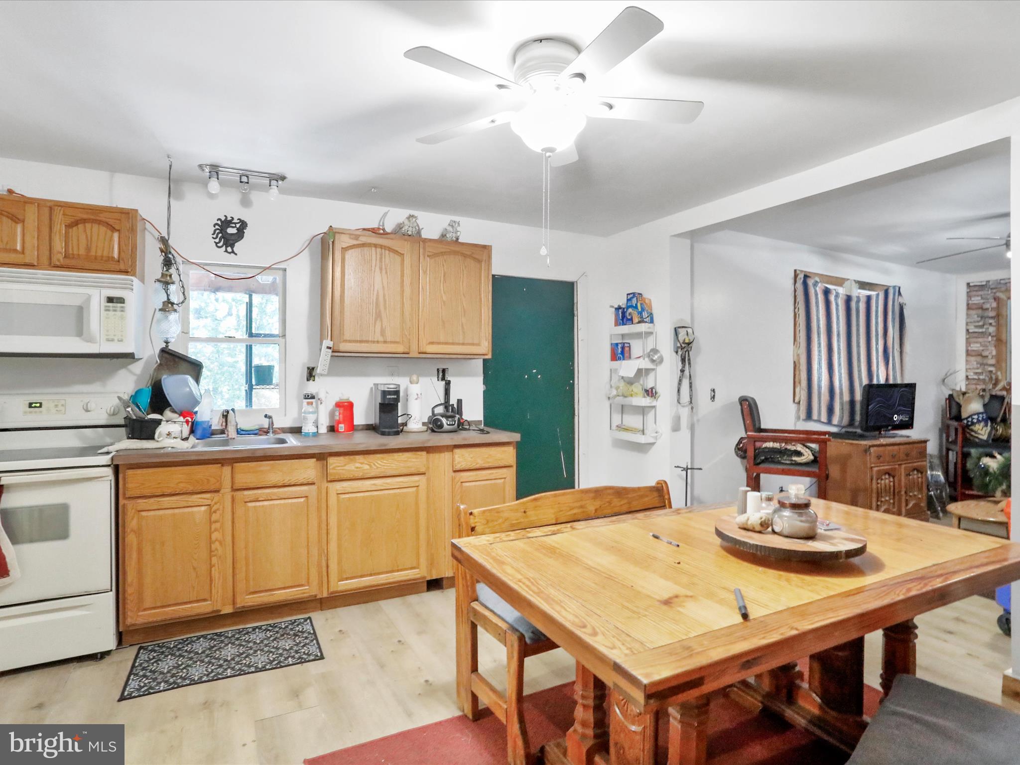 2370 Kerns School Road Springfield, WV 26763 - Photo 19 of 45 a kitchen with stainless steel appliances granite countertop a dining table and chairs with wooden floor