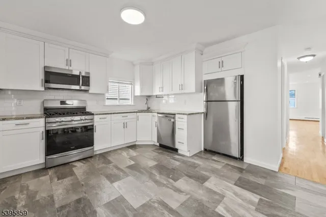 a kitchen with stainless steel appliances granite countertop a refrigerator stove a sink and a microwave