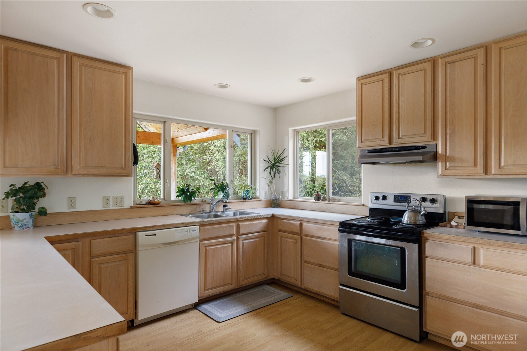 5474 Wilkinson Road Langley, WA 98260 - Photo 11 of 40 a kitchen with granite countertop a sink stove and cabinets