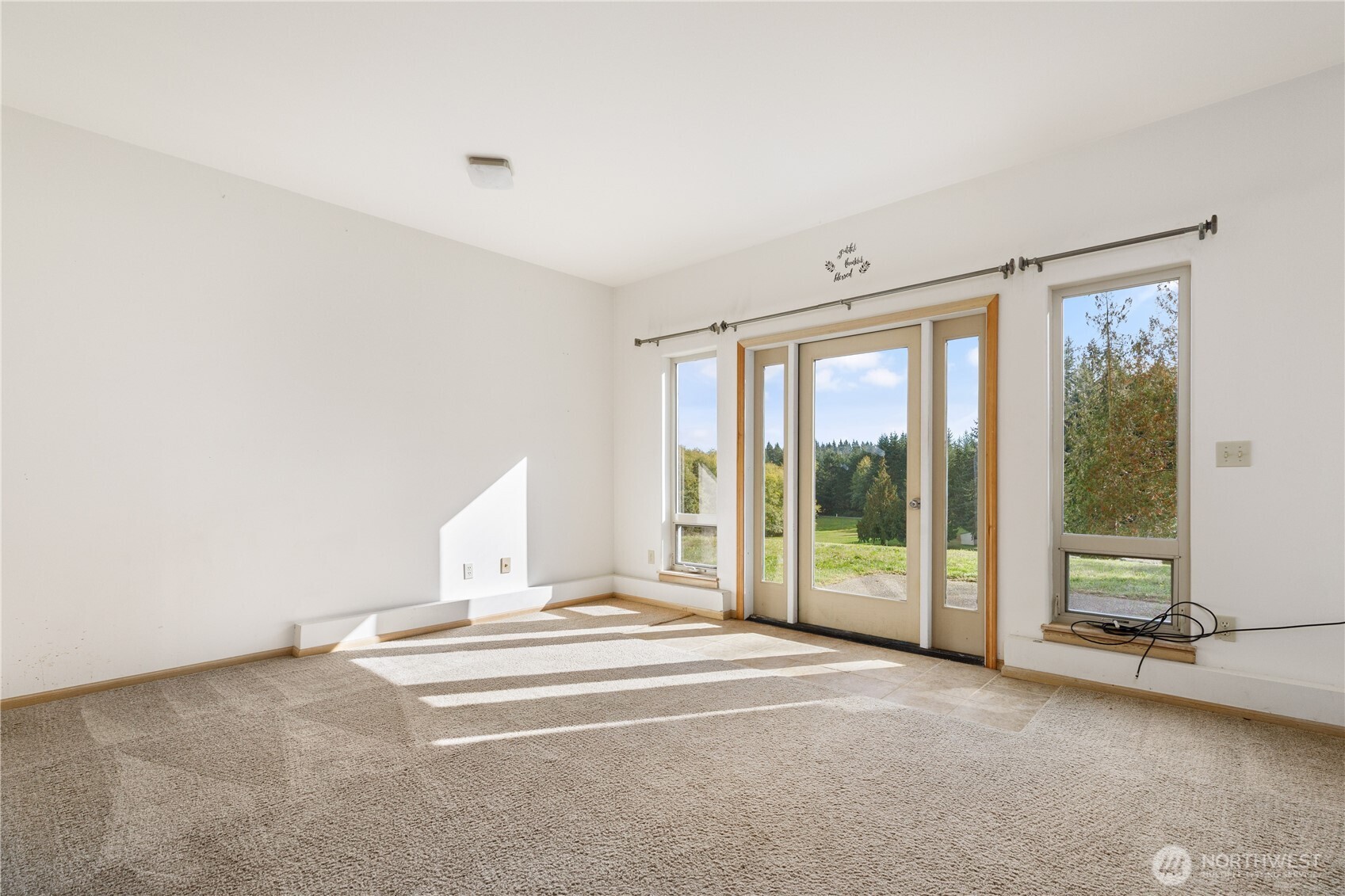 5474 Wilkinson Road Langley, WA 98260 - Photo 23 of 40 a bedroom with a bed and glass door