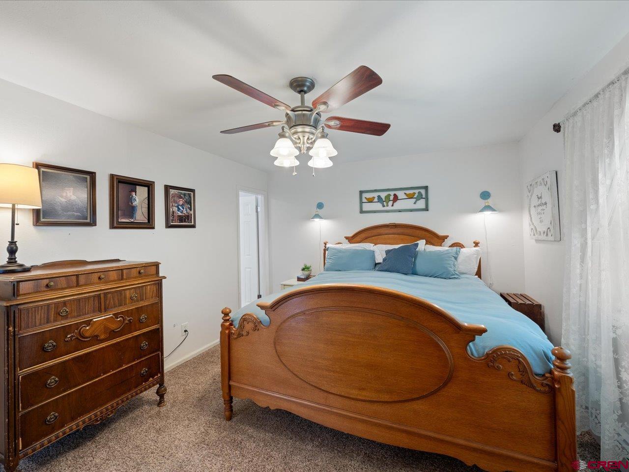 68184 Tumbleweed Road Montrose, CO 81403 - Photo 17 of 35 a bedroom with a bed and a chandelier