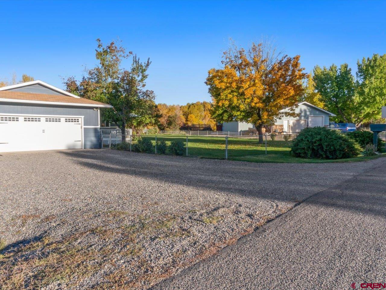 68184 Tumbleweed Road Montrose, CO 81403 - Photo 2 of 35 a front view of a house with a yard and trees