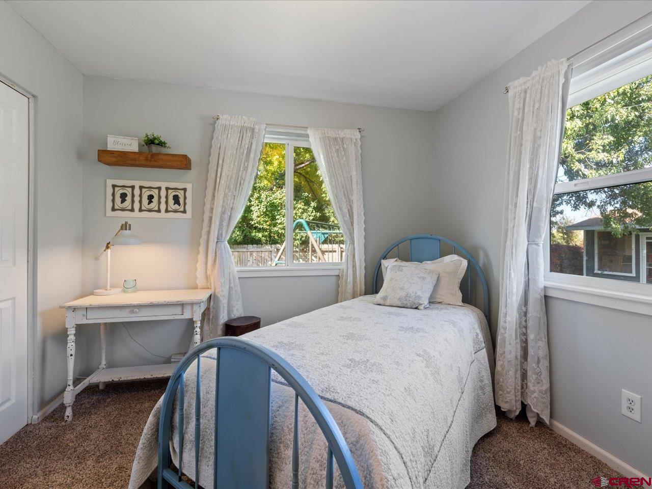 68184 Tumbleweed Road Montrose, CO 81403 - Photo 23 of 35 a bedroom with a bed and a table in it