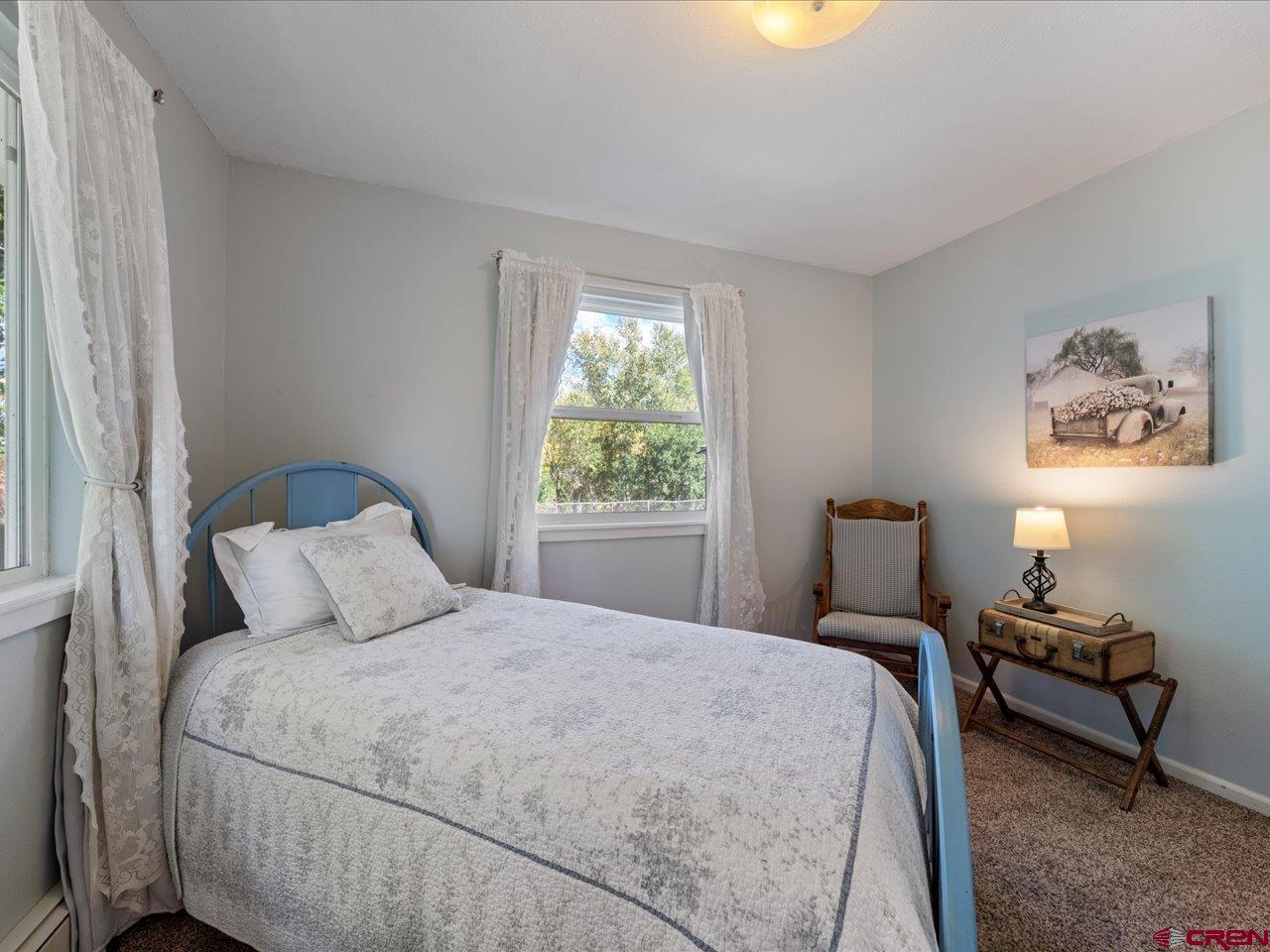 68184 Tumbleweed Road Montrose, CO 81403 - Photo 24 of 35 a bedroom with a bed and wooden floor
