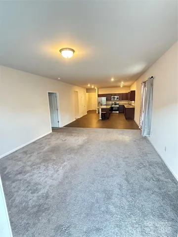 an empty room with furniture and a large window