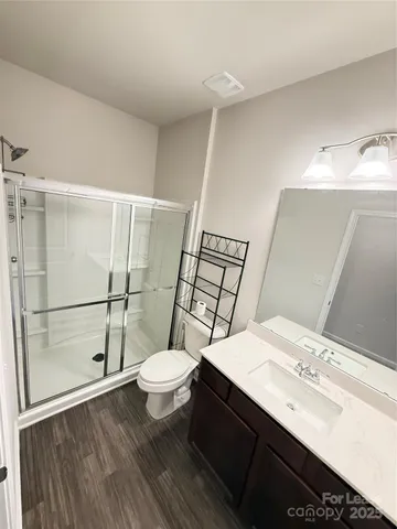 a bathroom with a sink a toilet a mirror and shower
