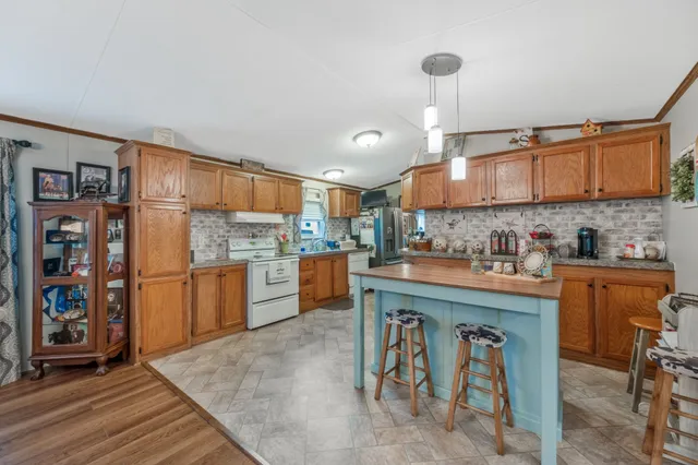 a kitchen with stainless steel appliances granite countertop a refrigerator and a stove top oven