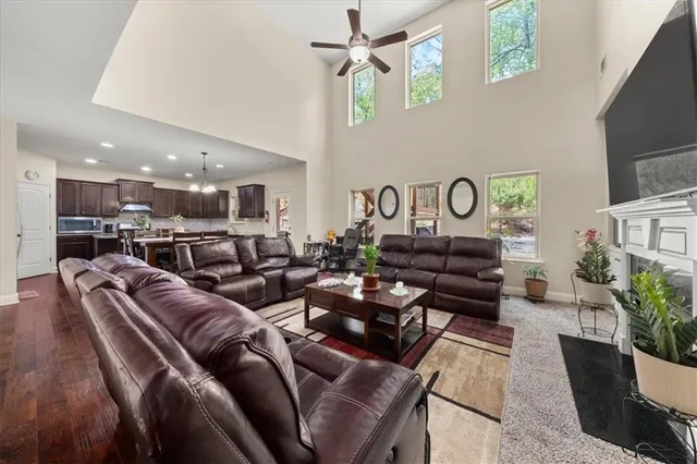 a living room with furniture kitchen view and a chandelier