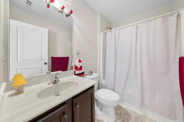 a bathroom with a sink vanity mirror and toilet