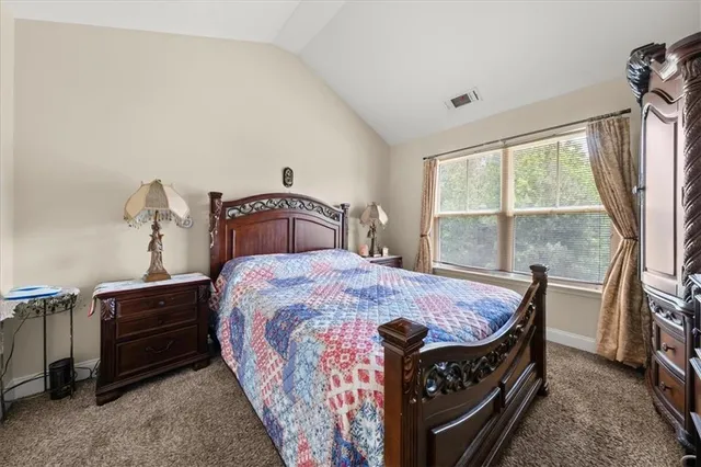 a bed sitting in a bedroom next to a window