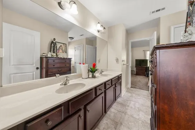 a bathroom with a sink double vanity granite tub shower and a mirror
