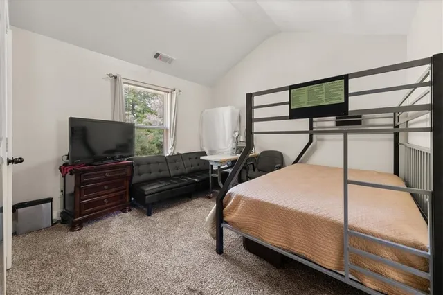 a bedroom with a bed and a flat tv screen on wall