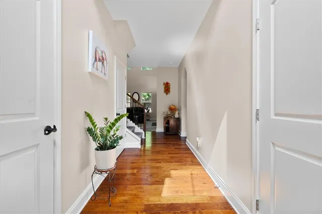 a hallway with wooden floor and a potted plant