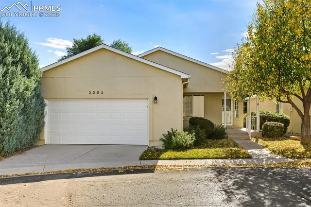 a view of a house with a yard and large tree