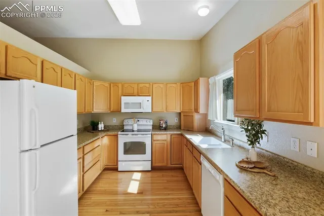 a kitchen with granite countertop a sink stainless steel appliances a counter top space and cabinets