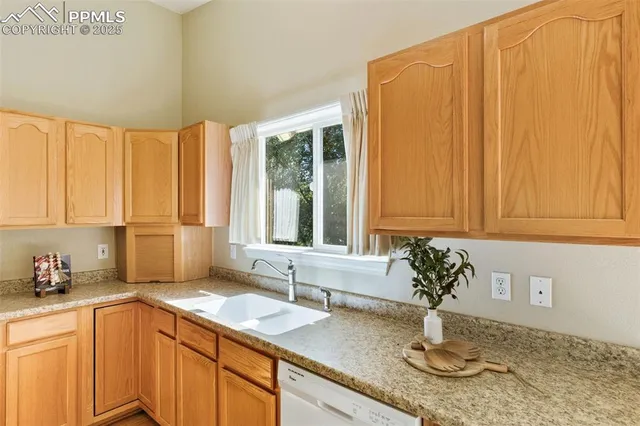 a kitchen with a sink a window and cabinets