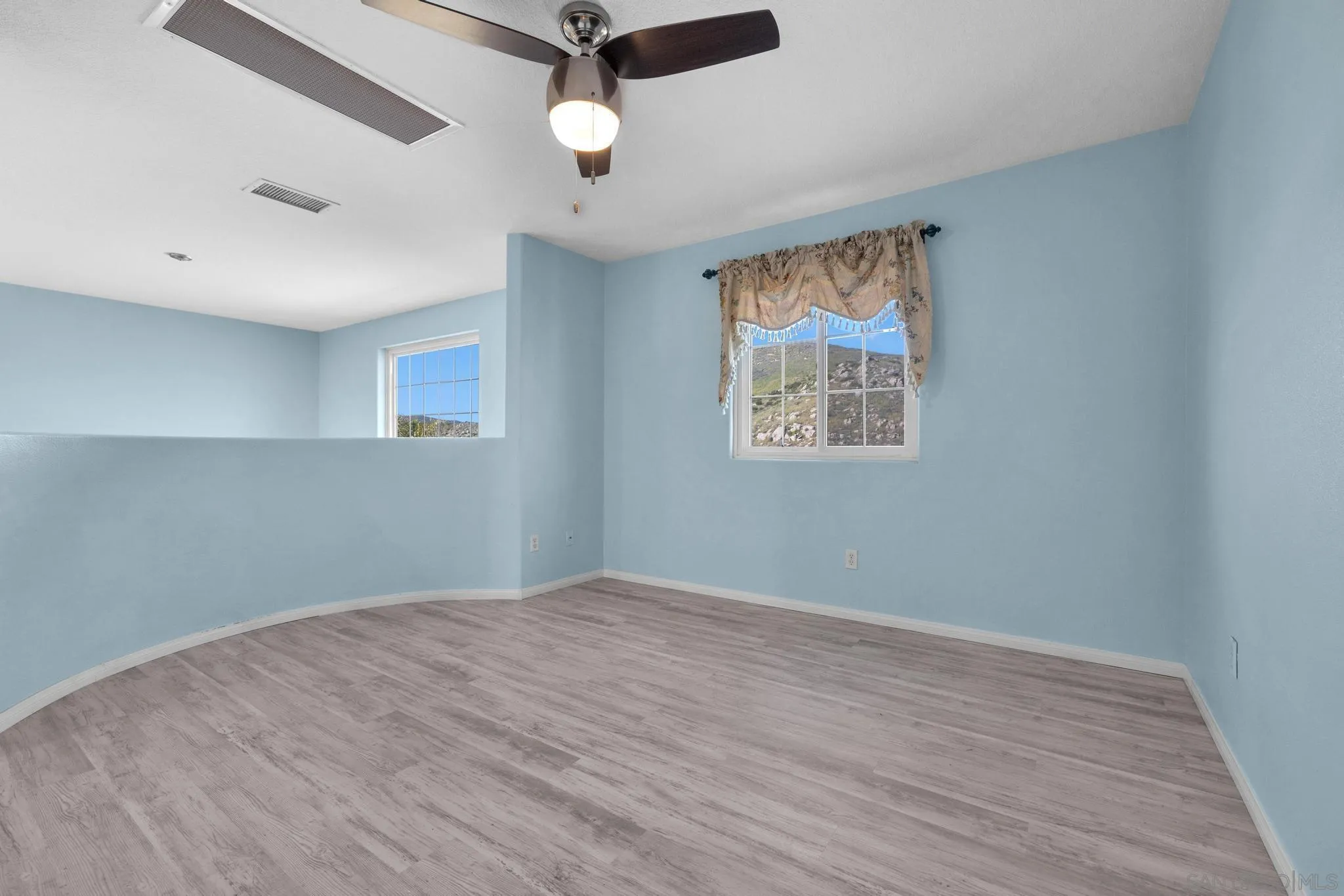 35140 Stirrup Road Temecula, CA 92592 - Photo 39 of 75 an empty room with wooden floor fan and windows