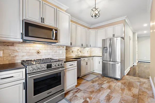 a kitchen with stainless steel appliances granite countertop a stove a sink and a refrigerator