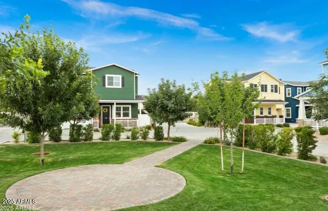 a view of a house with a big yard plants and large trees