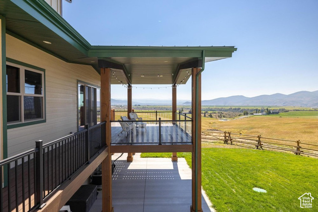 6117 North Rocky Ridge Road Peoa, UT 84061 - Photo 22 of 83 Wooden deck with a mountain view, a yard, a rural view, and a patio area