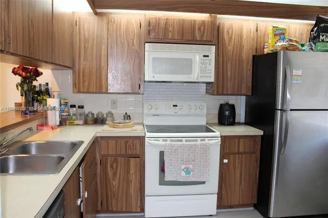 a kitchen with a refrigerator sink and cabinets