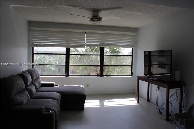 a living room with furniture a window and a flat screen tv
