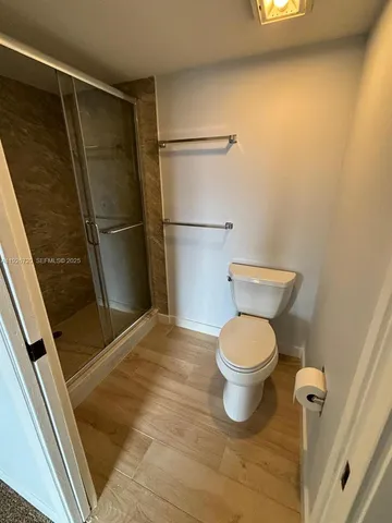 a bathroom with a toilet and a shower